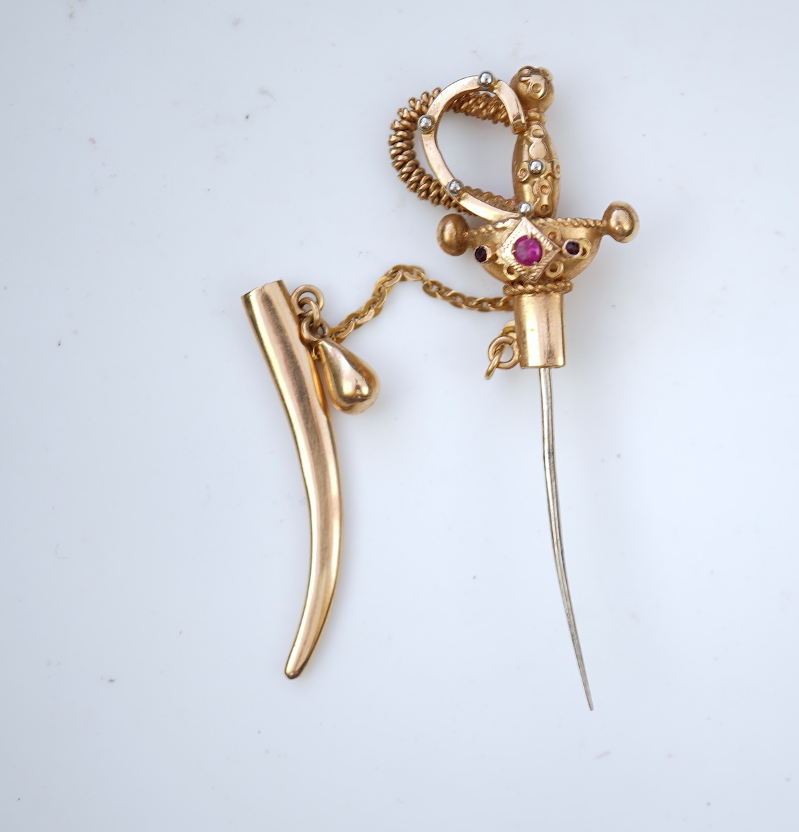 A gold and synthetic ruby jabot pin